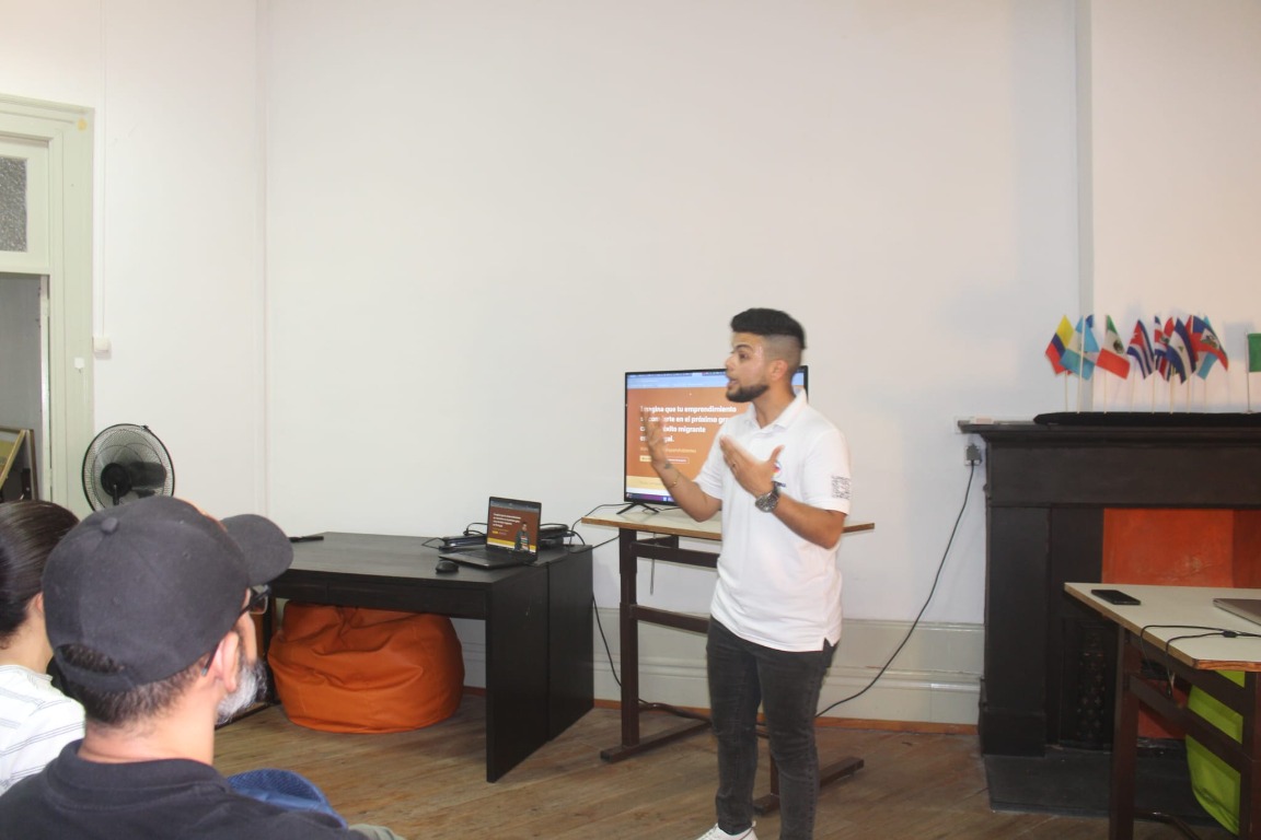 Foto de Gen presentando en un evento de Huellatina
